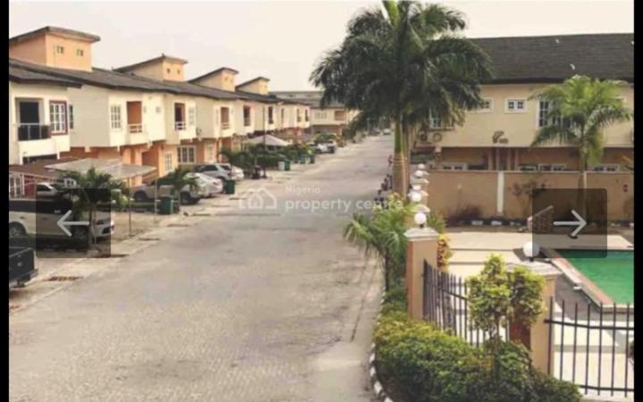 an empty street with houses and a palm tree at Peace Home in Lekki