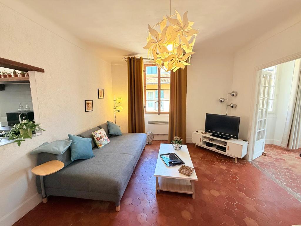 un salon avec un canapé et une télévision dans l'établissement Typical Niçois apartment in the heart of old town, à Nice