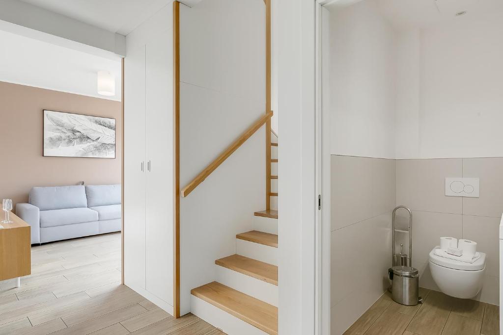 Viganello Modern Apartments في لوغانو: غرفة ذات جدران بيضاء ودرج مع مرحاض