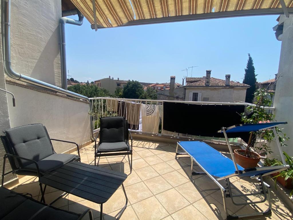 a patio with chairs and a table on a balcony at Guest House Marta in Rovinj