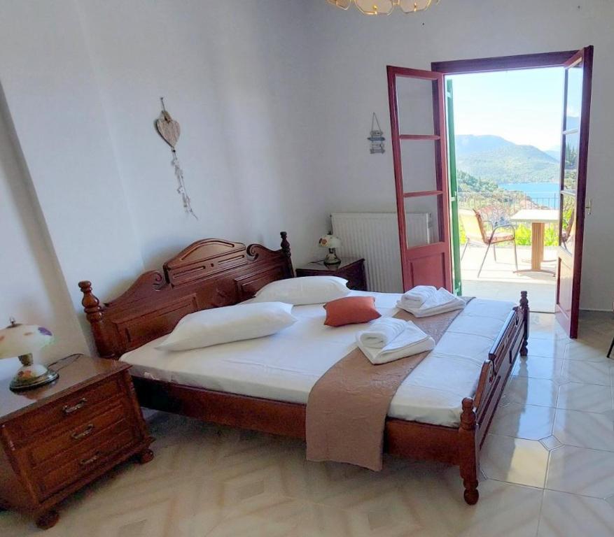 a bedroom with a large bed and a sliding glass door at SERENITY Apartments 1 in Vathi, Ithaka