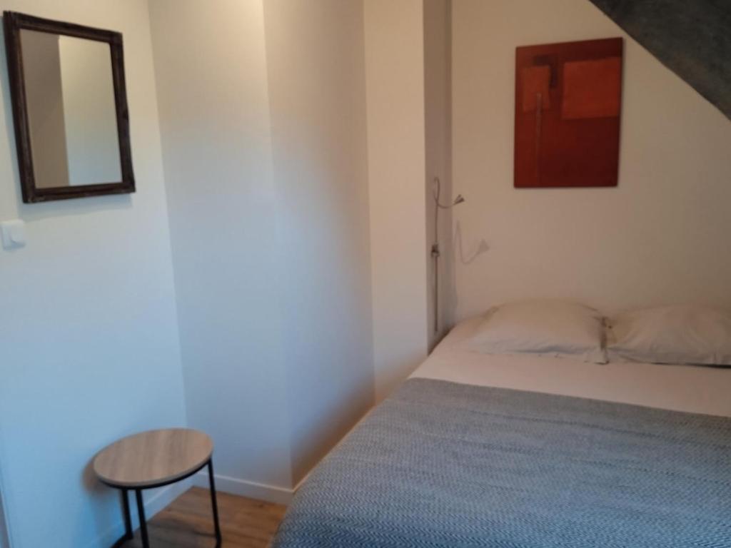 a bedroom with a bed and a table and a mirror at La Durdent - Domaine du Presbytère in La Chapelle-sur-Dun
