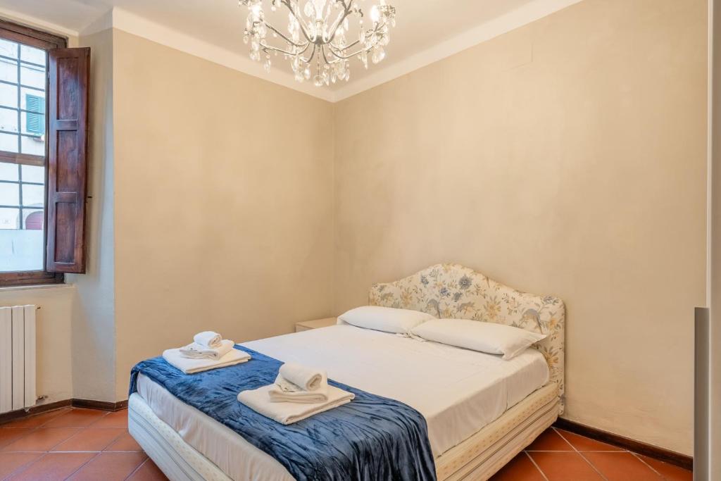 a bedroom with a bed and a chandelier at I Fossi Apartment - Lucca in Lucca