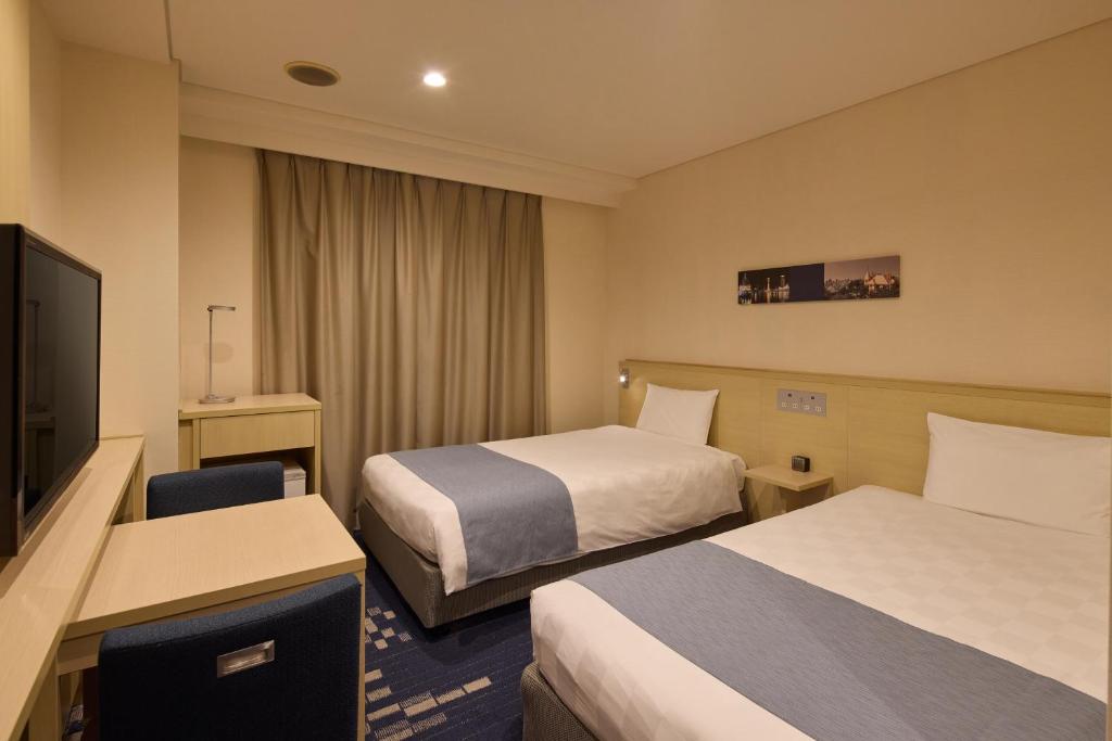 Postel nebo postele na pokoji v ubytování Kobe Sannomiya Tokyu REI Hotel