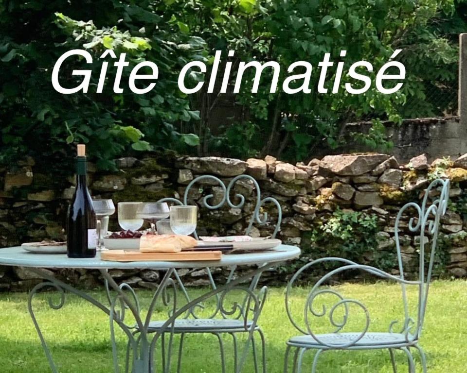 - une table avec une bouteille de vin et 2 chaises dans l'établissement L'instant Beaujolais 2 ou 4 personnes Logis cosy balnéo vue jardin, à Theizé