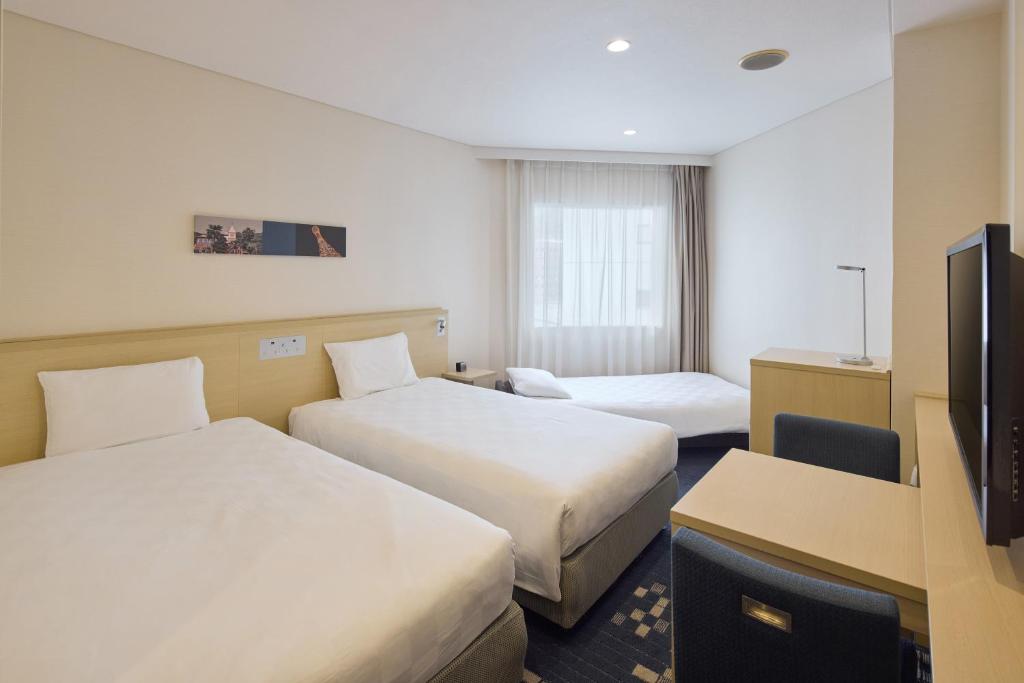 Postel nebo postele na pokoji v ubytování Kobe Sannomiya Tokyu REI Hotel