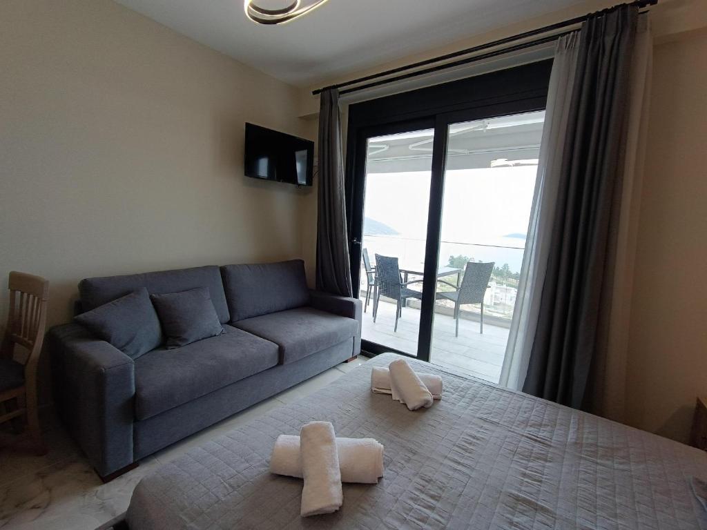 a living room with a couch and a large window at ALTA MARE in Nea Peramos