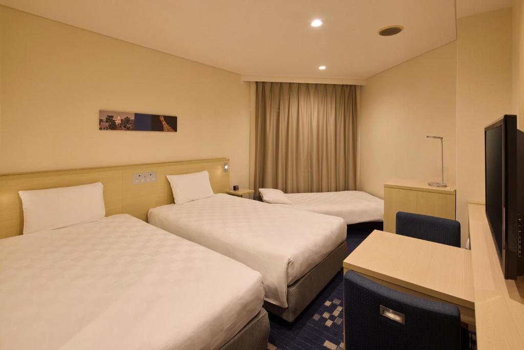 Postel nebo postele na pokoji v ubytování Kobe Sannomiya Tokyu REI Hotel