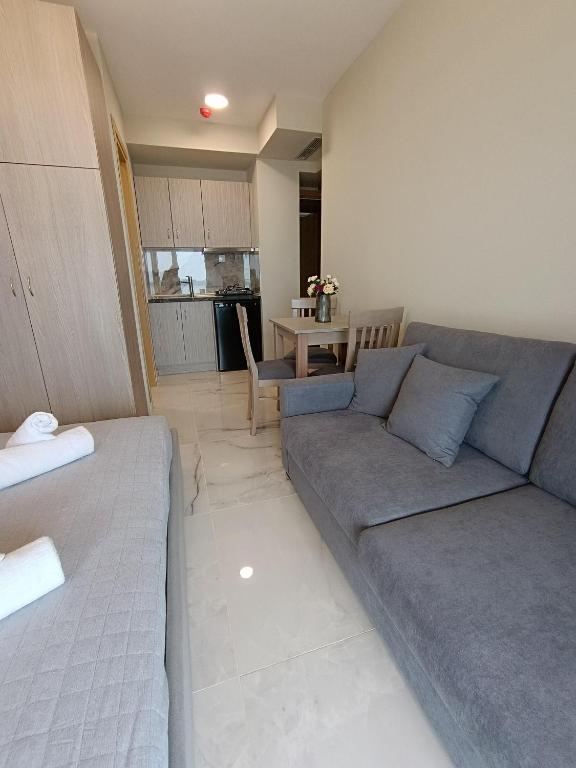 a living room with a couch and a table at ALTA MARE in Nea Peramos