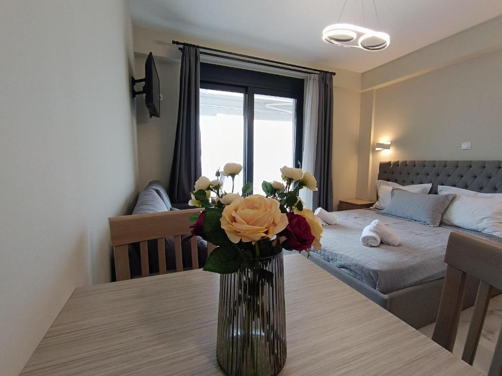 a vase with flowers on a table in a room at ALTA MARE in Nea Peramos