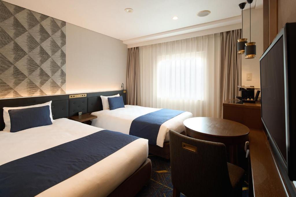 Postel nebo postele na pokoji v ubytování Kobe Sannomiya Tokyu REI Hotel