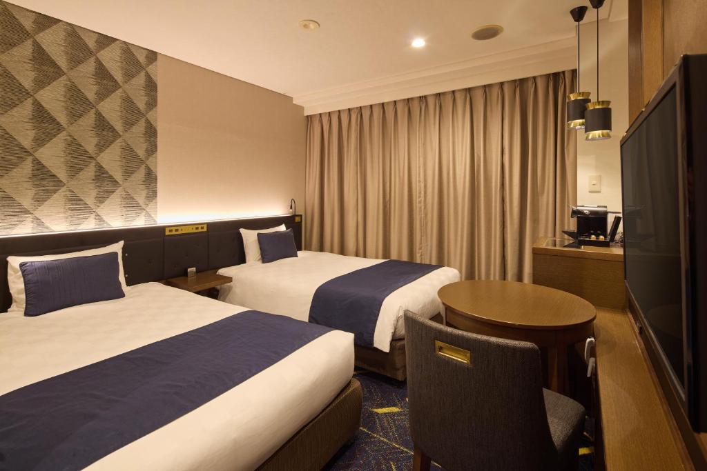 Postel nebo postele na pokoji v ubytování Kobe Sannomiya Tokyu REI Hotel