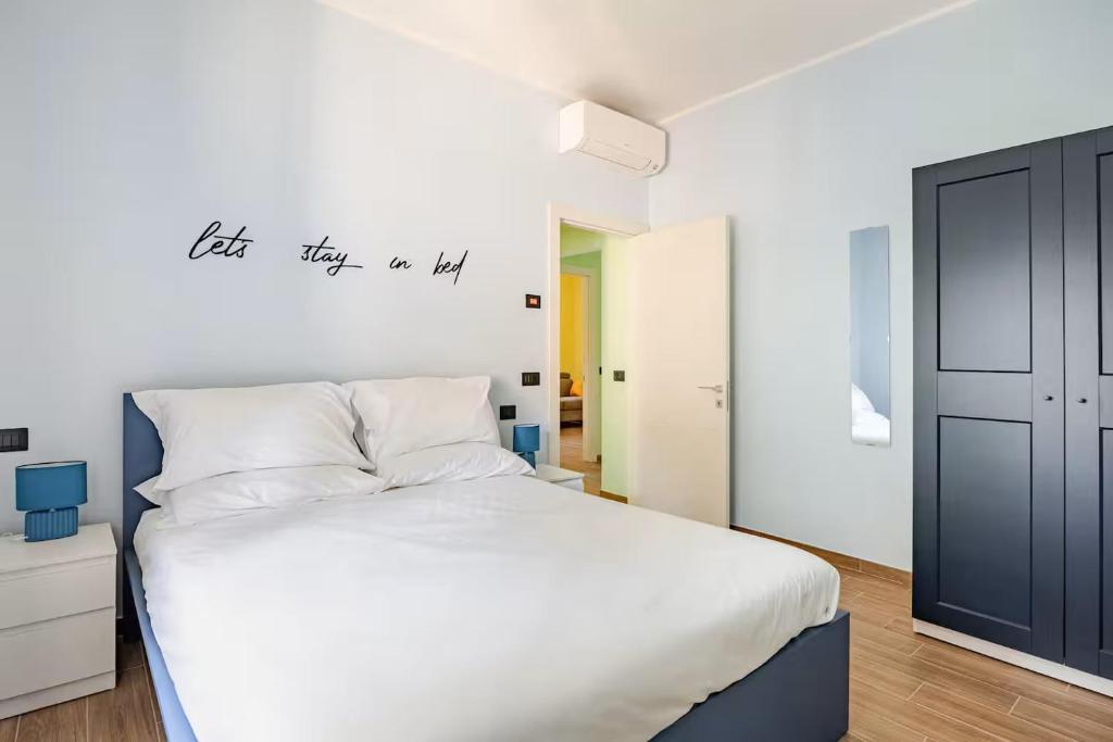 a bedroom with a large white bed with a sign on the wall at Appartamento del Paradosso in Spilamberto