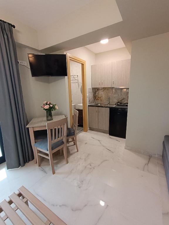 a living room with a table and a kitchen at ALTA MARE in Nea Peramos