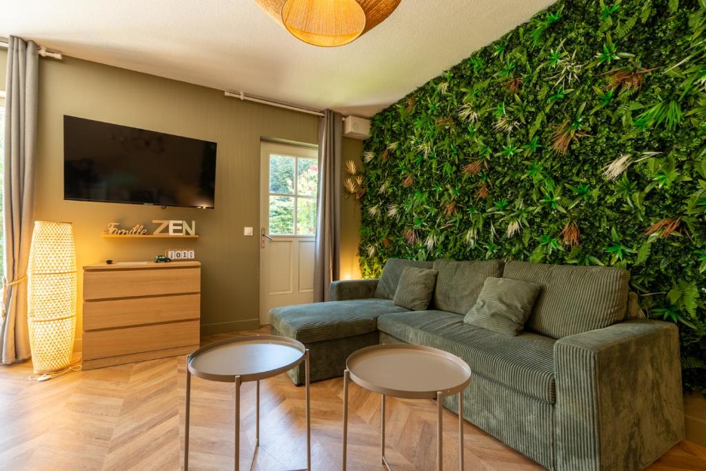 a living room with a green wall with a couch and two tables at Gite "Douce Campagne" - Terrasse - 3 Chambres - Lits King & Queen size, lits superposés in Saint-Josse