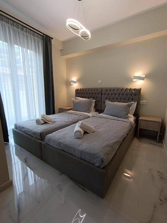 a bedroom with two beds and a large window at ALTA MARE in Nea Peramos