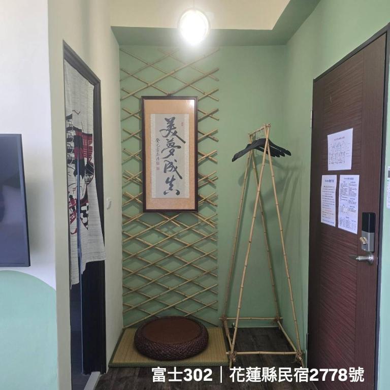 Cette chambre est dotée d'un mur avec une étagère et une porte. dans l'établissement Kunba Homestay, à Hualien