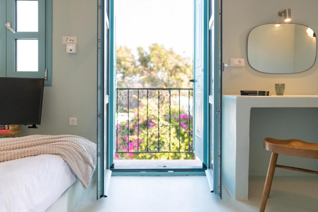 a bedroom with a door open to a balcony at Via Vasileia in Kattavía