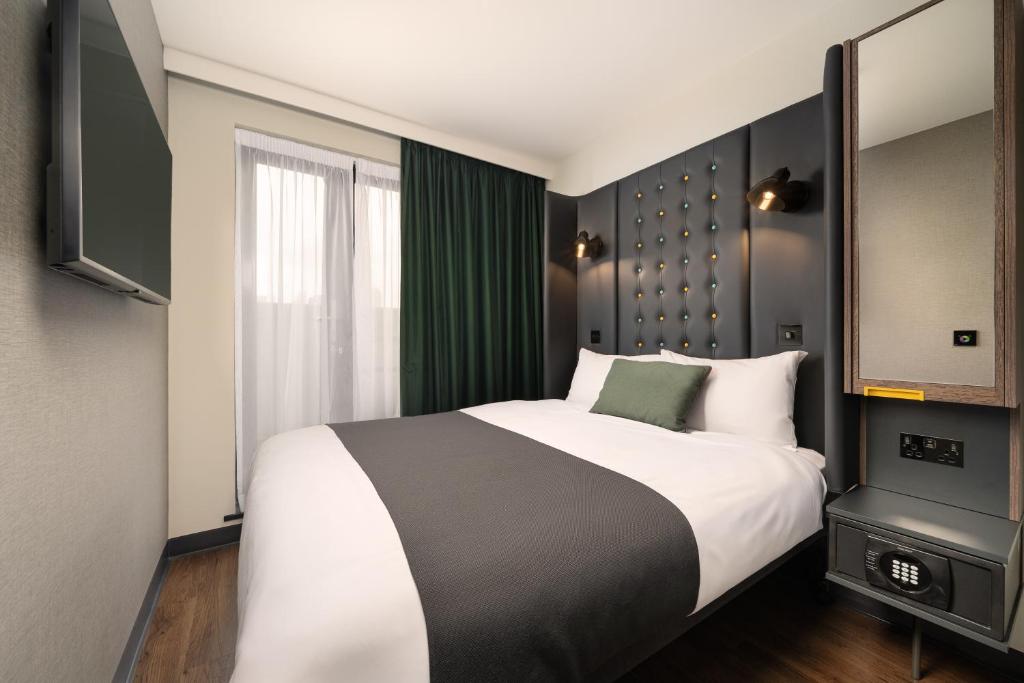 una camera da letto con un letto grande e una finestra di Point A Hotel London Westminster a Londra