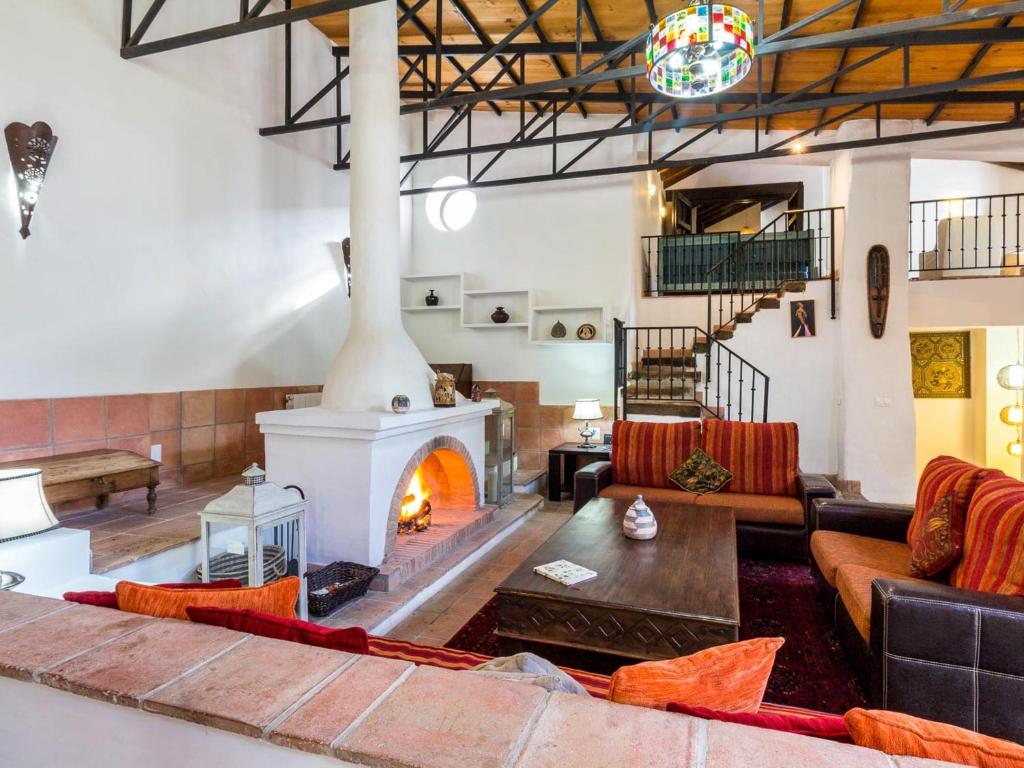 a living room with a fireplace and a couch at Molino Arroyo in Guájar-Faragüit