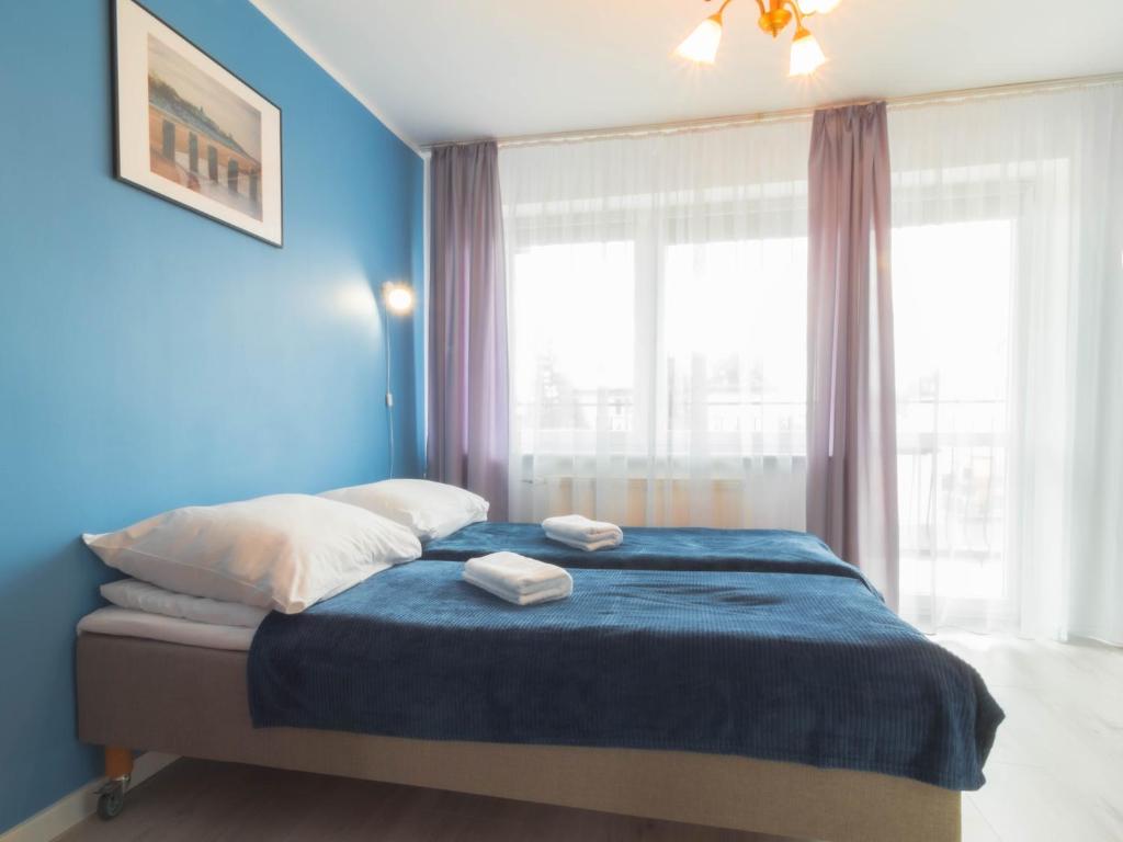 a blue bedroom with a bed with two towels on it at Willa Niezapominajka Mielno in Mielno