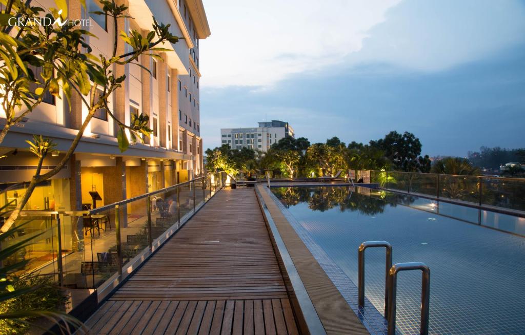 una pasarela de madera junto a un edificio con piscina en I Hotel en Nagoya