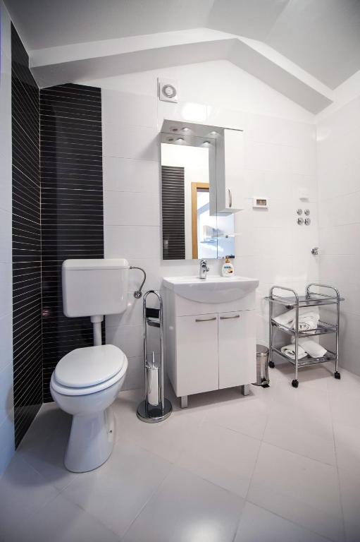 biała łazienka z toaletą i umywalką w obiekcie Apartments Centener w Rovinj