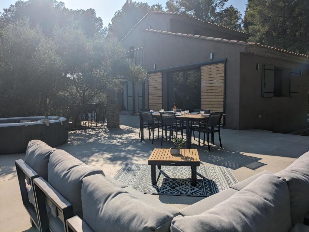 un patio avec un canapé, une table et des chaises dans l'établissement Havre de paix entre mer et pinède, à Ceyreste