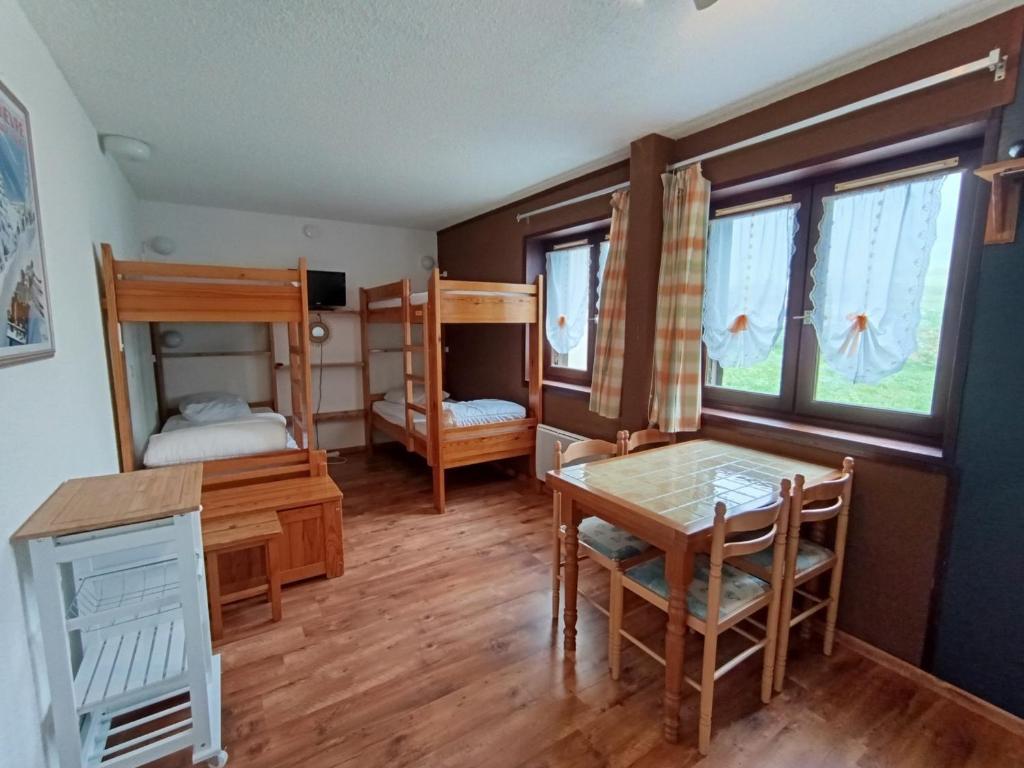 une chambre avec deux lits superposés et une table et des chaises dans l'établissement Studio économique 4 pers - 1* - Animaux admis - Centre village Montgenèvre - FR-1-445-75, à Montgenèvre