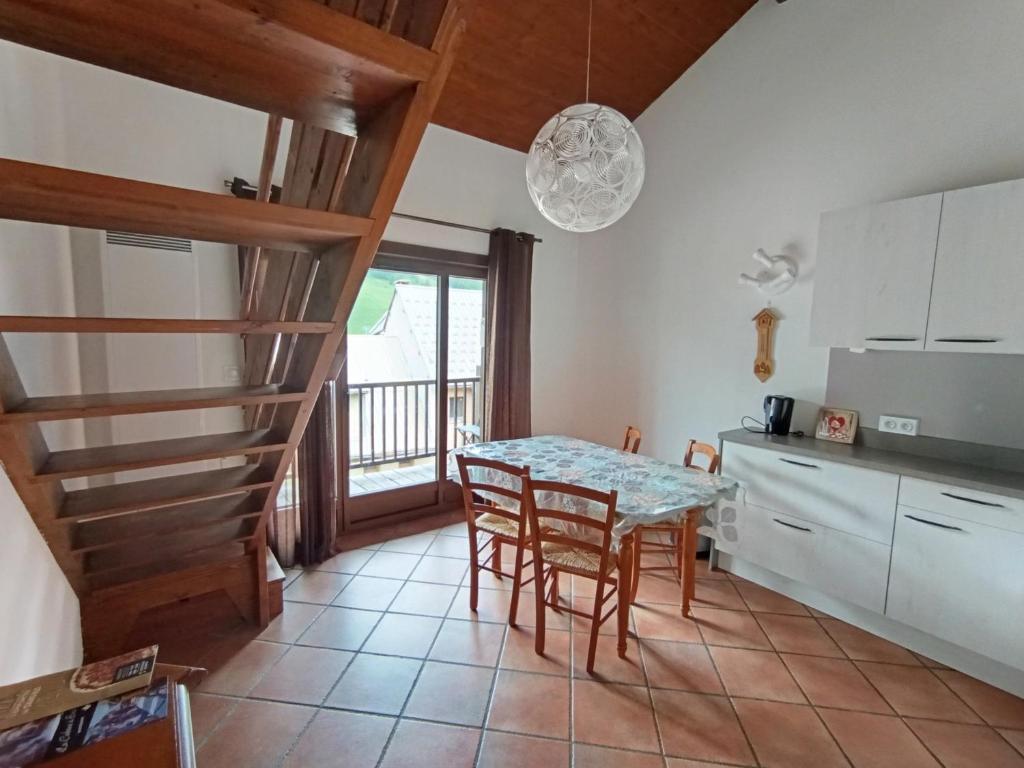 une cuisine avec une table et des chaises dans une pièce dans l'établissement Duplex 3* pour 4 pers - Centre village, à 100m des pistes - Confort et charme - FR-1-445-129, à Montgenèvre