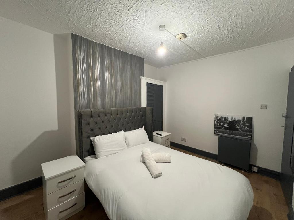 ロンドンにあるBethnal Green Nestのベッドルーム(白い大型ベッド、ナイトスタンド付)