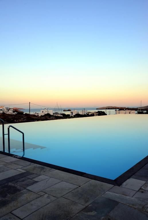 a swimming pool with blue water in the foreground at ANEMI Folegandros in Karavostasi