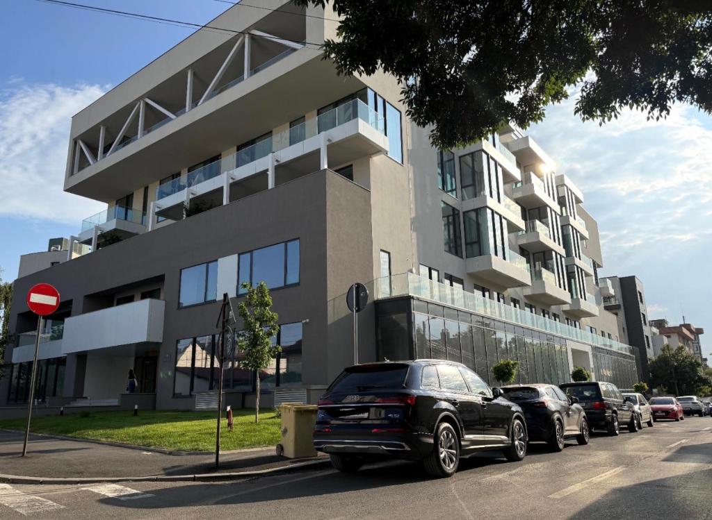 ein schwarzes Auto, das vor einem Gebäude geparkt ist in der Unterkunft Walter Loft Luxury Residence- Self Check-in & Underground Parking in Bukarest