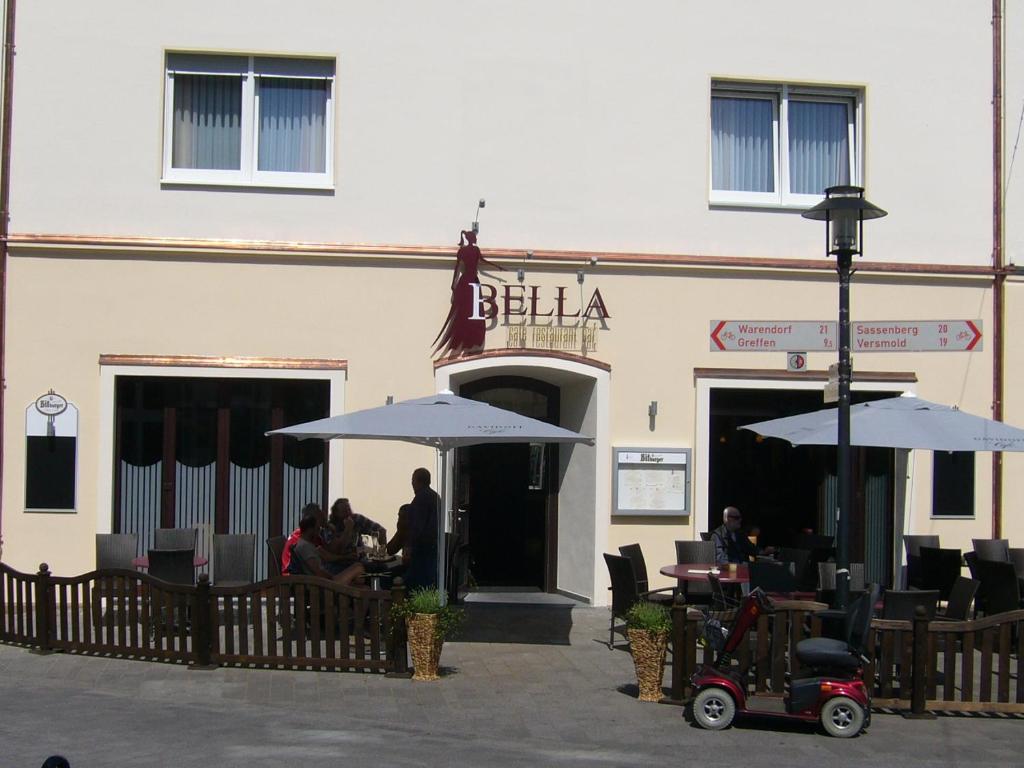 a restaurant with people sitting at tables and umbrellas at Hotel Amadis in Harsewinkel