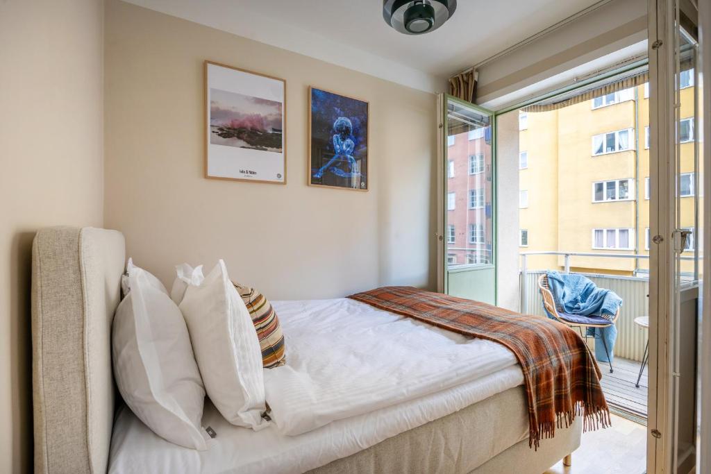 a bedroom with a bed and a large window at The Best Apartment in Stylish Sodermalm Stockholm in Stockholm