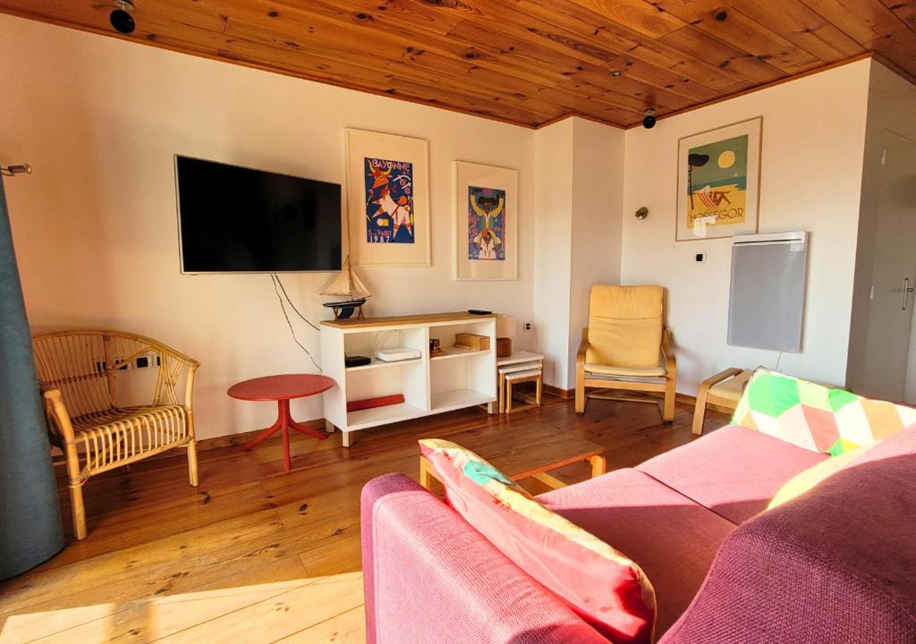 un salon avec un canapé et une télévision à écran plat dans l'établissement Atlantique - L'océan Atlantique à porter de main, à Soorts-Hossegor
