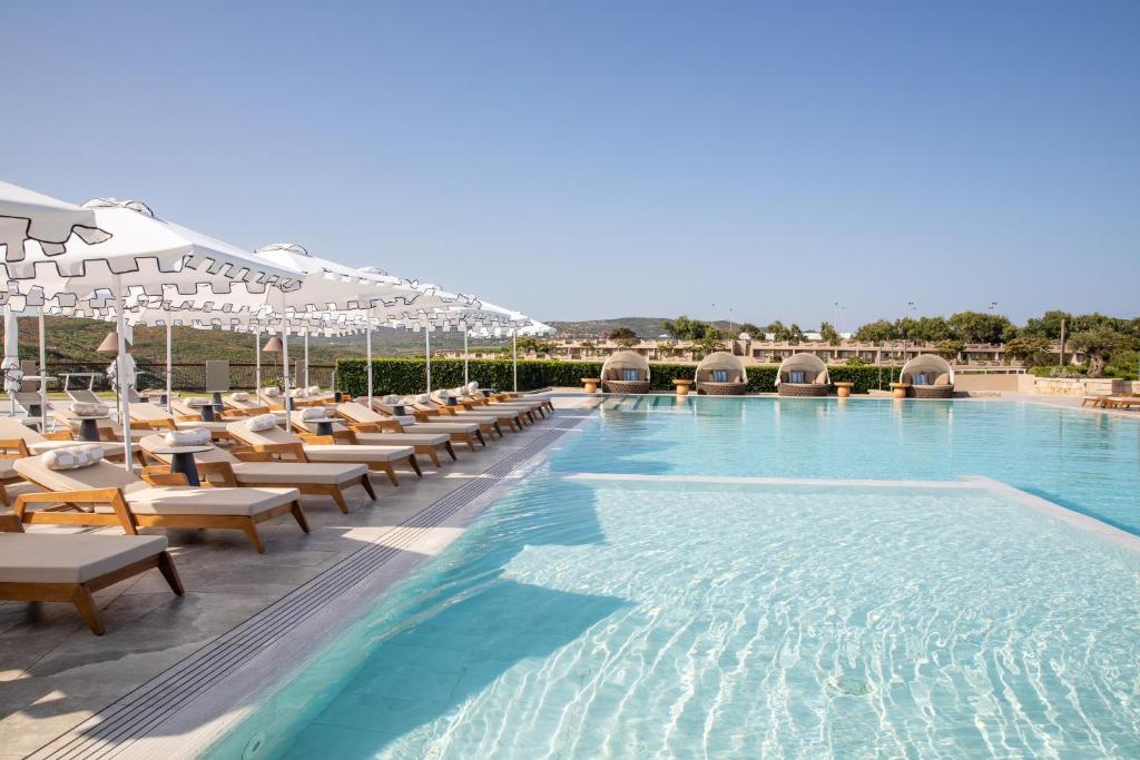 a pool with chaise lounge chairs and a swimming pool at Mangia's Sardinia Resort - NEW OPENING in Santa Teresa Gallura