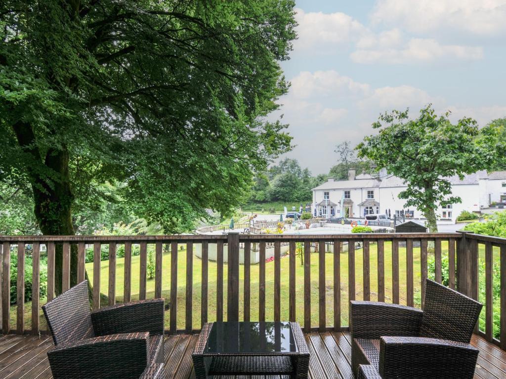 a deck with chairs and a table and a fence at Valley Lodge 2 in Callington