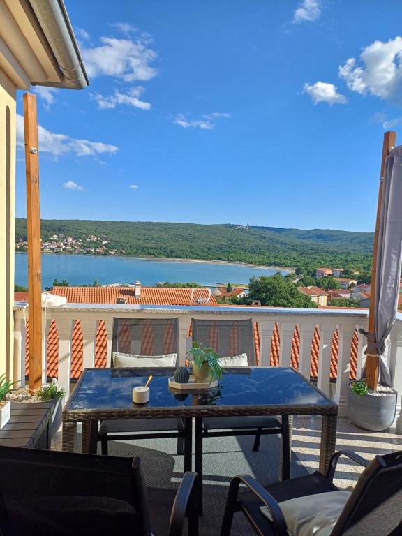 a table on a balcony with a view of the water at 16 Čižići in Čižići