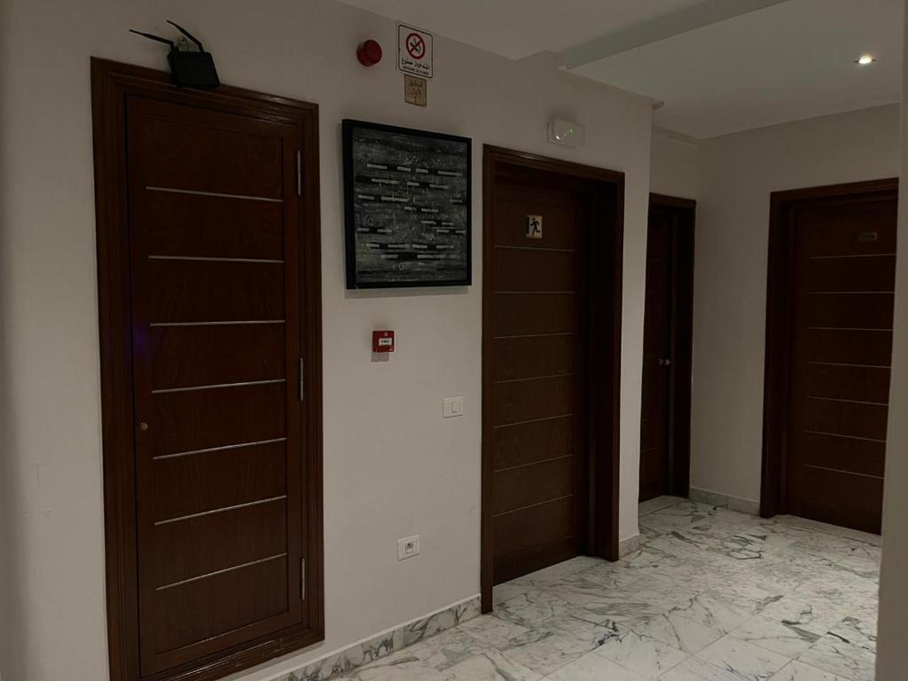 a hallway with two wooden doors and a tile floor at Pacha hotel in Sfax