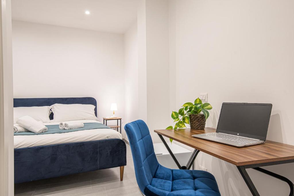 Un dormitorio con una cama y un escritorio con una computadora portátil. en Pallaro 6 room, en Roma