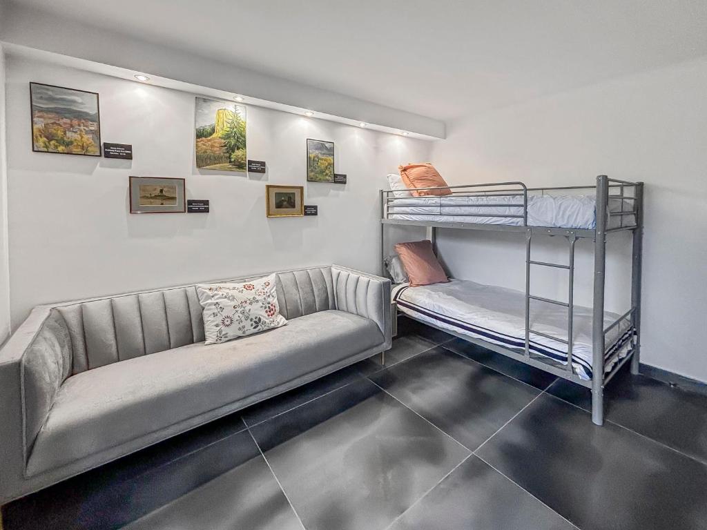 a living room with a couch and bunk beds at Villa avec jacuzzi, sauna&cinéma in Triel-sur-Seine