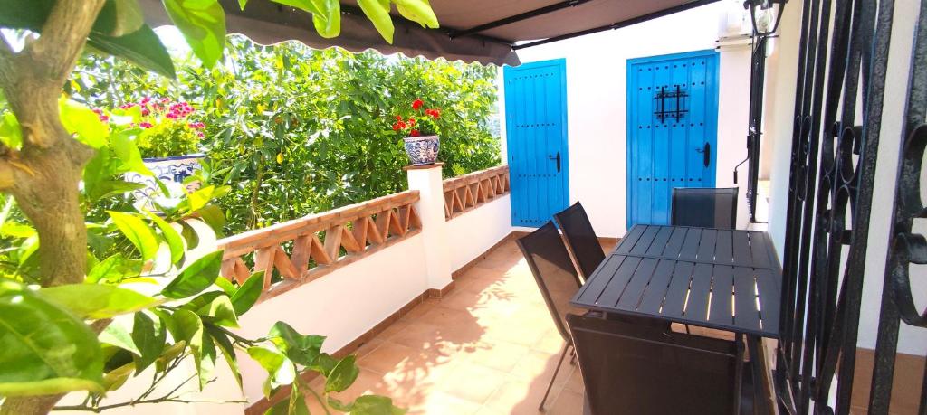 a balcony with blue doors and a table at El Carmen de Sexi in Almuñécar