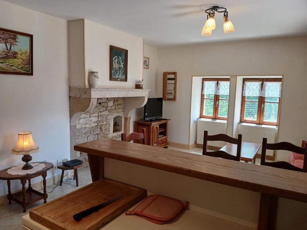 a living room with a table and a fireplace at Maison vacances 4 personnes in Mont-Saint-Jean