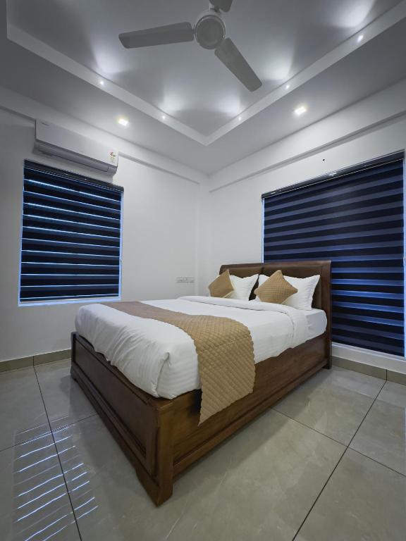 a bedroom with a large bed with blue blinds at The Nexus Hotel Kakkanad in Kakkanad