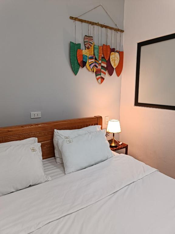 a bedroom with a bed with white sheets at An Homestay & Hostel Motorbikes & Tours in Cao Bằng