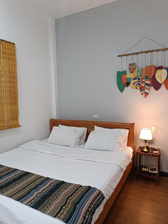a bedroom with two beds and a table with a lamp at An Homestay & Hostel Motorbikes & Tours in Cao Bằng