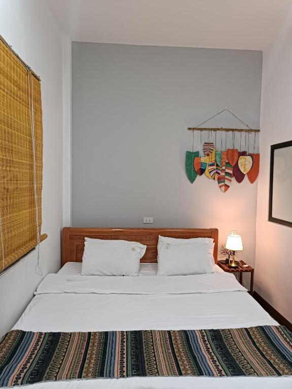 a bedroom with a bed with white sheets at An Homestay & Hostel Motorbikes & Tours in Cao Bằng