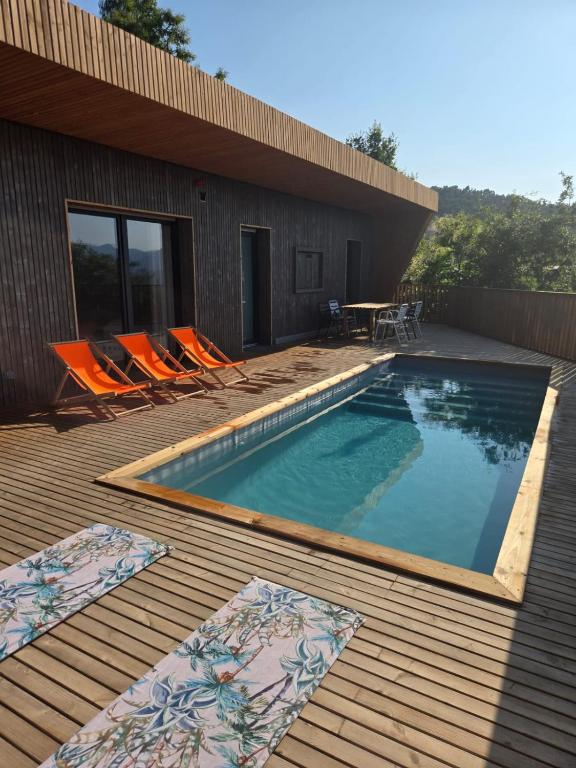 a swimming pool with chairs and a table on a deck at VERDVILLAGE in Valença