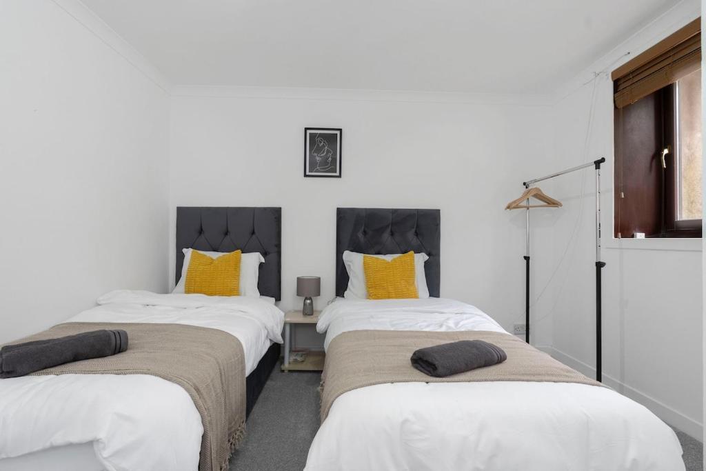 - une chambre avec 2 lits et des oreillers jaunes dans l'établissement Free Parking - Sleeps 6 - 2 Bedrooms - Newly Renovated, à Greenock